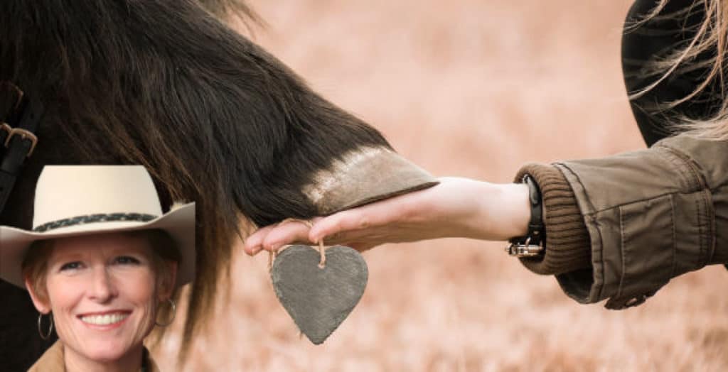Lynn Baber cowboy hat woman's hand and horse's hoof touching with stone heart dangling from her hand