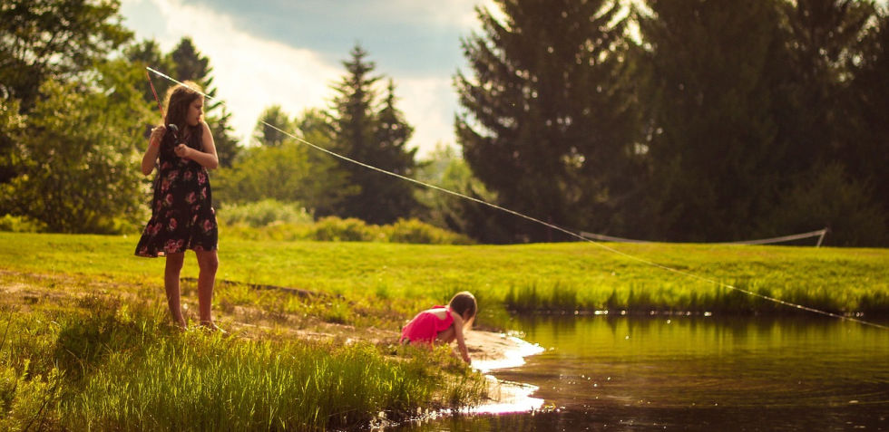 Two girls casting a fishing line in a pond. The first necessary element to be an overcomer is showing up.