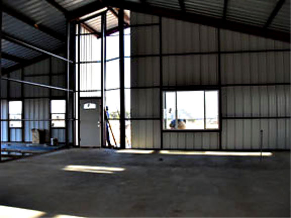 Barndominium in the building process with soaring ceilings and concrete floor.