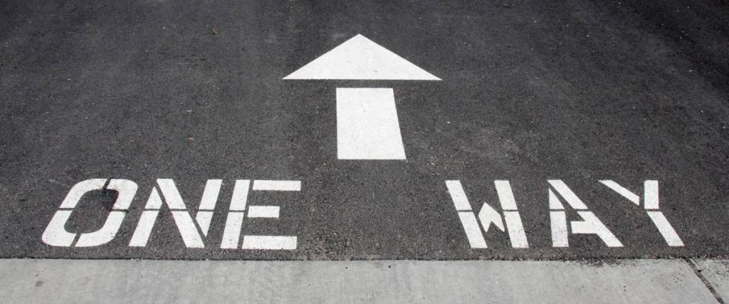 one way words and arrow painted on gray roadway. Jesus Christ is the only way