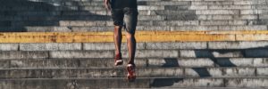 man in work out gear running up stadium stairs