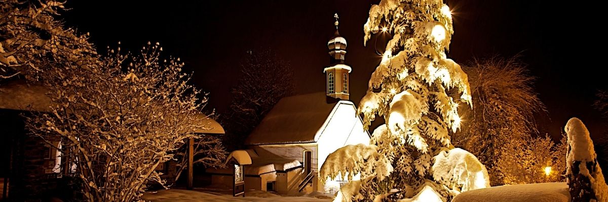 church snow Christmas golden light at night